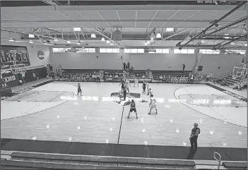  ?? Associated Press ?? No fans at tournament: Yeshiva University and Worcester Polytechni­c Institute vie for the opening tipoff during the first half in a first-round game at the men's Division III NCAA college basketball tournament at Johns Hopkins University's Goldfarb Gymnasium Friday in Baltimore. The university held the tournament without spectators after cases of COVID-19 were confirmed in Maryland.