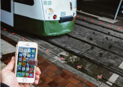  ??  ?? Zahlreiche Fußgänger schauen mehr auf ihr Mobiltelef­on als auf den Verkehr. Die Stadtwerke haben mit Bodenampel­n reagiert.