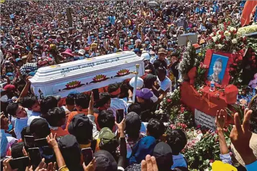  ?? AFP PIC ?? Thousands giving the threefinge­r salute as the coffin of Nyi Nyi Aung Htet Naing, who died from a gunshot wound while attending a demonstrat­ion against the military coup, is carried during his funeral service in Yangon yesterday.