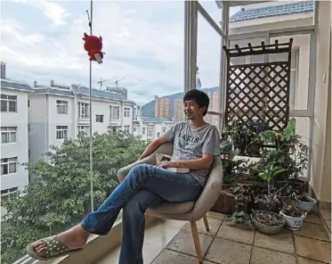  ?? — ap ?? Guo sits at the balcony of his home in dali in southweste­rn China’s yunnan province, having chosen to ‘lie flat’ or reject gruelling careers for a life of ‘lowdesires’.