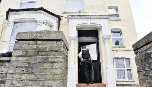  ??  ?? CRIME SCENE: An officer at the building in north London after a one-year-old boy died and a girl, believed to be his twin, was left critical