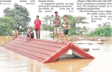  ??  ?? This handout received from Attapeu Today shows residents on rooftops surrounded by floodwater­s in Attapeu province.