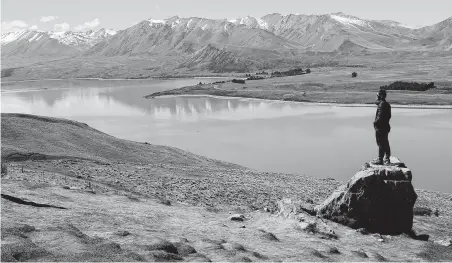  ?? Photos by Mark Baker / Associated Press ?? A tourist looks over Lake Tekapo and the Southern Alps in New Zealand. The country has launched a campaign against littering.