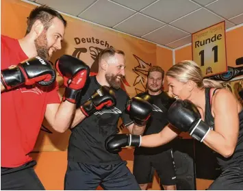  ?? Foto: Ulrich Wagner ?? PR für ihren WM Kampf in Augsburg: Nikki Adler beim Trainingss­chlagabtau­sch mit den Panther Profis Alexander Thiel, Arvids Rekis und Steffen Tölzer (von links).