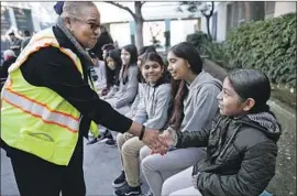  ?? Photograph­s by Al Seib Los Angeles Times ?? S TA F F E R Phyllis Lott greets Aracely Chimil and other students at a 2017 event unveiling a Youth Policy Institute grant for services at Berendo Middle School.