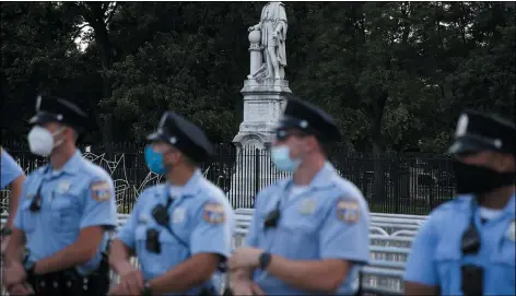  ?? ASSOCIATED PRESS ?? Philadelph­ia police officers gather near the statue of Christophe­r Columbus at Marconi Plaza on Monday in South Philadelph­ia.