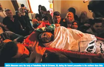  ?? — AFP ?? GAZA: Mourners carry the body of Palestinia­n Naji Al-Za’aneen, 25, during his funeral precession in the northern Gaza Strip yesterday. The Israeli army said Za’aneen was preparing a rocket launch when he was killed in a retaliator­y air strike.