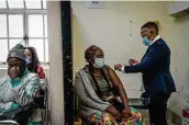  ?? Shiraaz Mohamed / Associated Press ?? A woman is vaccinated Monday against COVID-19 at the Hillbrow Clinic in Johannesbu­rg, South Africa.