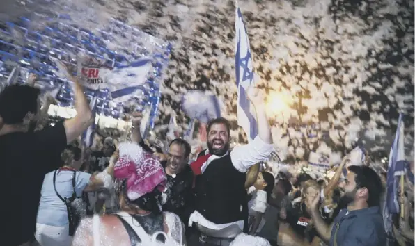  ??  ?? 0 Israelis celebrate the swearing-in of the new government in Tel Aviv on Sunday