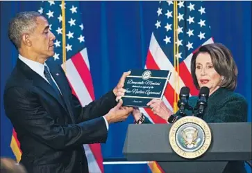  ?? Pablo Martinez Monsivais Associated Press ?? PRESIDENT OBAMA accepts a copy of Iran nuclear agreement legislatio­n from House Democratic leader Nancy Pelosi in 2016. President Trump pulled out of the deal in 2018, but the president-elect can sign back on.