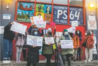  ?? PHOTO BY BRITTAINY NEWMAN ASSOCIATED PRESS ?? ABOVE: Teachers protest on issues related to lack of coronaviru­s testing outside P.S. 64 in New York City. The nation’s largest school system will send out 2 million at-home test kits provided by the state.