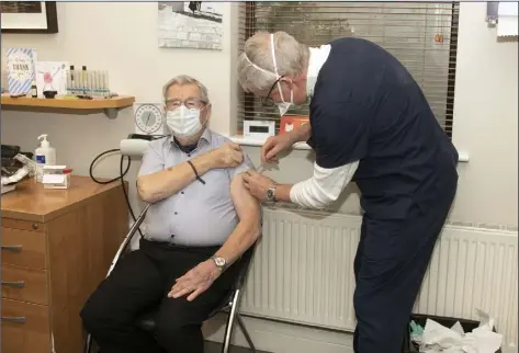  ??  ?? Dr David Curtis administer­s the Covid vaccine to his 92 year-old father Dr Bart Curtis.