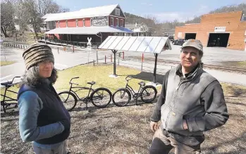  ?? PAUL KUEHNEL/AP PHOTOS ?? Ellen Darby, left, and David Keller stand with the restoratio­ns they have made to Seitzland Village, outside of Glen Rock, on March 18. The exterior of the store was restored with new porches, the store front rebuilt and a train station was added. The York County Heritage Rail Trail runs in the background.