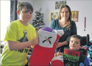  ?? GREG MCNEIL/CAPE BRETON POST ?? Sean, Nichol and Devon MacNeil are shown with some of the Christmas stockings they have collected for children who are in hospital over the holidays. Children in the pediatric and neonatal intensive care unit will receive the gifts prior to Christmas.