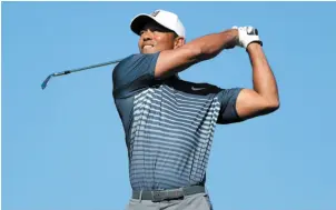  ?? AP PHOTO ?? Tiger Woods watches his tee shot on the 15th hole on the North Course at Torrey Pines during the second round of the Farmers Insurance Open on Friday in San Diego.