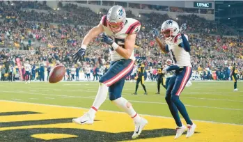  ?? GENE J. PUSKAR/AP ?? Patriots tight end Hunter Henry celebrates after scoring as teammate Tyquan Thornton, right, watches during the first half last Thursday. The Patriots held off the Steelers 21-18.