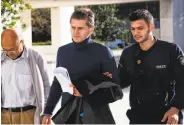  ?? Louisa Gouliamaki / AFP / Getty Images ?? Alexander Vinnik (center) is accused of laundering $4 billion using the virtual currency bitcoin.