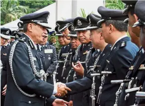  ??  ?? End of an era: DCP Jaafar (left) bidding farewell to his officers after handing over his duties at the state police contingent headquarte­rs in Seremban.