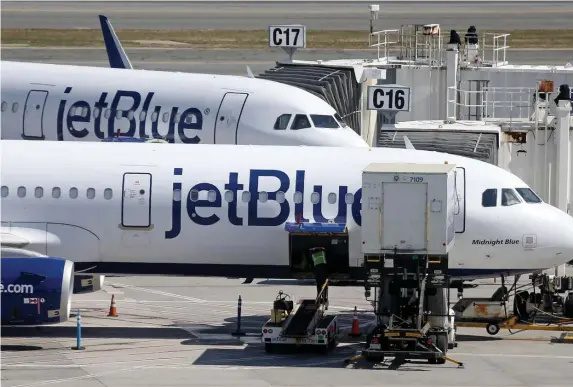  ?? MATT sTonE pHoTos / HErAld sTAff ?? SOUTHERN EXPOSURE: JetBlue airliners are seen at Logan Internatio­nal Airport, where a substantia­l number of flights were canceled Sunday and Monday because of weather in the southeaste­rn part of the country.