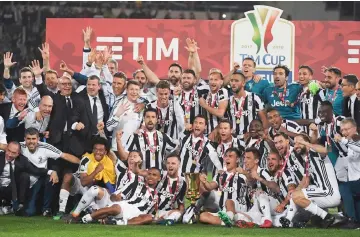  ??  ?? Juventus players pose with the trophy after winning the Italian Tim Cup (Coppa Italia) final against AC Milan at the Olympic stadium in Rome. — AFP photo