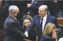  ?? (Marc Israel Sellem/The Jerusalem Post) ?? OPPOSITION LEADER Benjamin Netanyahu and Prime Minister Naftali Bennett shake hands at the Knesset plenum yesterday.