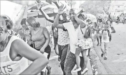  ?? ?? ▲ Habitantes de Puerto Príncipe huyen de los enfrentami­entos entre policías y pandillas. Foto Ap