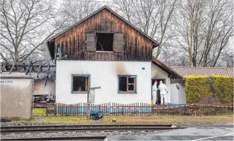  ?? FOTO: CHRISTIAN FLEMMING ?? Nach dem Brand des ehemaligen Bahnwärter­hauses in Lindau-Zech suchen Bereitscha­ftspolizis­ten im Haus und in der Umgebung nach Spuren. Die Brandursac­he steht noch nicht fest.