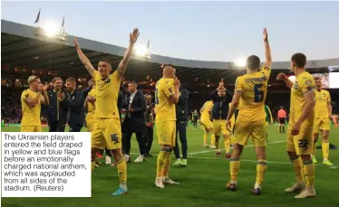  ?? (Reuters) ?? The Ukrainian players entered the field draped in yellow and blue flags before an emotionall­y charged national anthem, which was applauded from all sides of the stadium.