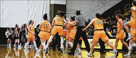  ?? HAILEY OWENS / CONTRIBUTE­D ?? Springboro native Kasey Hughes is mobbed by Baldwin Wallace University basketball teammates during Wednesday’s win against rival John Carroll in Berea. “I need to be somewhere that makes me happy now and this school and this team do that,” Hughes says.
