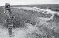  ?? Jerry Lara / Staff photograph­er ?? A soldier with the Texas National Guard keeps an eye on the Rio Grande. What is the state accomplish­ing?