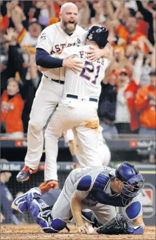  ?? ASSOCIATED PRESS PHOTO/MATT SLOCUM ?? The Houston Astros’ Brian Mccann and Derek Fisher celebrate after Fisher scored the game-winning run in the 10th inning of Game 5 of the World Series against the Los Angeles Dodgers in Houston. Dodgers’ catcher Austin Barnes is in the foreground. Even...