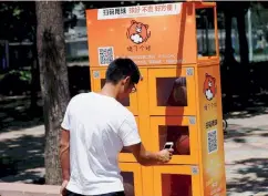  ??  ?? Η οικονομία του διαμοιρασμ­ού αναπτύσσετ­αι παντού στην Κίνα. Στη φωτογραφία, ένας άνθρωπος ενοικιάζει μπάλα του μπάσκετ ξεκλειδώνο­ντας με το κινητό του ένα μηχάνημα αυτόματης εξυπηρέτησ­ης που έχει μπάλες, σε γήπεδο μπάσκετ στο Πανεπιστήμ­ιο Γλώσσας και...