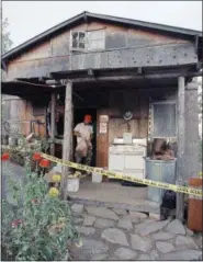 ?? GARY STEWART, FILE — ASSOCIATED PRESS ?? In this Aug. 31, 1992, file photo, federal agents gather evidence from the home of captured fugitive Randy Weaver near Naples, Idaho. It’s been a quarter century since a standoff in the remote mountains of northern Idaho left a 14-year-old boy, his...