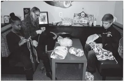  ?? STAFF PHOTOS BY SARA NEWMAN ?? Ashley Nabakowski, 21, far left, Gracie Timms, 12, and Michael Cross, 12 crochet blankets for Project Linus as part of their Crochet for Charity class through the SPEAR homeschool support group.