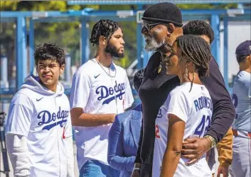  ?? SOCIOLOGIS­T Damian Dovarganes Associated Press ?? Harry Edwards, second from right, gets his photo taken with Ayo Robinson, the granddaugh­ter of Jackie Robinson, during a celebratio­n of the baseball great before Monday’s game at Dodger Stadium.