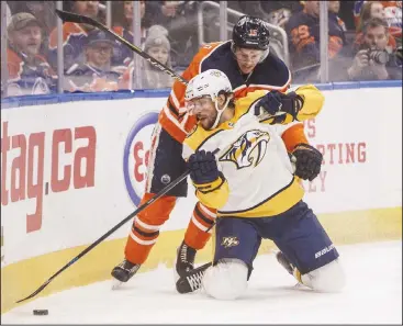  ??  ?? Nashville Predators’ Craig Smith (15) and Edmonton Oilers’ Josh Archibald (15) battle for the puck during first period NHL hockey
action in Edmonton, Alberta, on Jan 14. (AP)