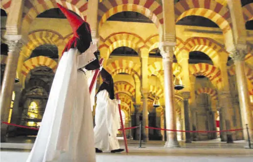  ?? CÓRDOBA ?? En el corazón de la Semana Santa Unos nazarenos en el interior de la Mezquita de Córdoba. ▷