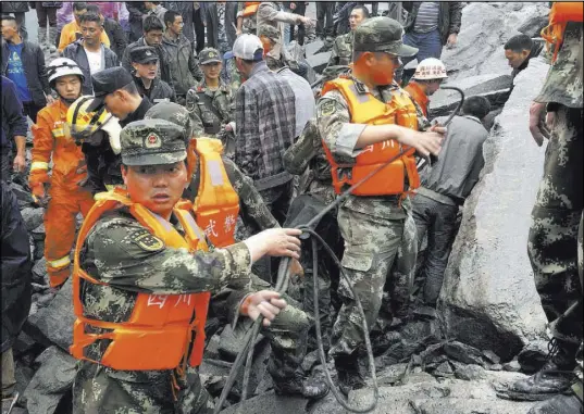  ?? The Associated Press ?? Emergency personnel work Saturday at the site of a landslide in Xinmo village in southweste­rn China’s Sichuan province.