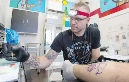  ??  ?? Toby Sicks works on a tattoo of a native eagle at his Inkdigenou­s studio in Toronto’s east end.