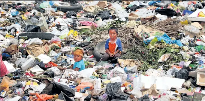  ?? GRANT LAFLECHE/ POSTMEDIA NETWORK ?? A baby and her brother sit in the garbage of the Jalapa landfi ll.