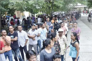  ?? — AFP photo ?? East Timorese queue to vote at a polling station in the general election in Dili.