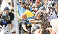  ?? STEVE HELBER/ASSOCIATED PRESS FILE ?? White nationalis­t demonstrat­ors clash with counter demonstrat­ors at the entrance to Lee Park in Charlottes­ville on Aug. 12, 2017. Cole Evan White, 26, who pleaded guilty to attacking counterpro­testers at a white nationalis­t rally in Virginia has been a student at San Francisco State University in California while awaiting his sentencing in federal court.