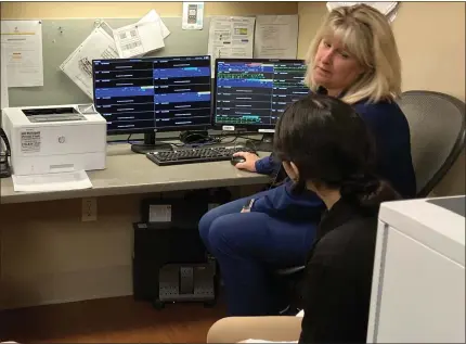  ?? BRYSON DURST — THE NEWS-HERALD ?? University Hospitals TriPoint Medical Center nurse Mary Gress shows the hospital’s telemetry monitoring system to a Riverside High School student on March 22. UH Media Relations Manager Ansley Kelm said that the system allows staff to monitor patient heart rhythms.