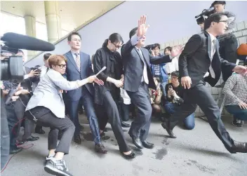  ?? — AFP file photo ?? Former Korean Air (KAL) executive Cho Hyun-ah (C) surrounded by journalist­s after receiving a suspended jail sentence at a court in Seoul.