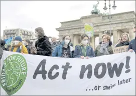  ?? MICHAEL SOHN — THE ASSOCIATED PRESS ?? People stand in front of the Brandenbur­g Gate as they take part in a “Fridays for Future” climate protest rally in Berlin, Germany, on Friday.