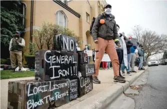  ?? PAT NABONG/ SUN- TIMES ?? A protester attends a rally near Mayor Lori Lightfoot’s Logan Square home Saturday, urging her to deny the final permit that would allow General Iron to move from Lincoln Park, a mostly white neighborho­od, to a Southeast Side neighborho­od which has a mostly Latino population.