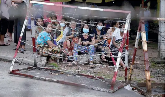  ?? Agence France-presse ?? ↑ People wait outside Insein Prison in Yangon, as authoritie­s announced more than 5,000 people jailed would be released on Monday.