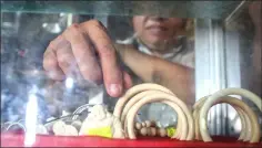  ??  ?? A vendor selling bracelets and figurines made of ivory and elephant hair at a shop at a tourist resort in Buon Don district.