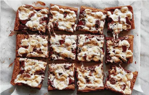  ?? Johnny Miller / New York Times; food styled by Erin Jeanne McDowell ?? With toasted marshmallo­ws, gooey chocolate and malty graham cracker flavor, these blondies offer all the finger-licking yumminess of s’mores.