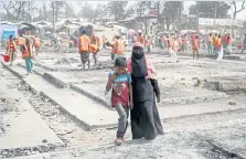  ??  ?? Mohammed Salim, 13, assists his mother Noor Banu, as they make their way to the Internatio­nal Organizati­on for Migration centre to collect relief supplies.